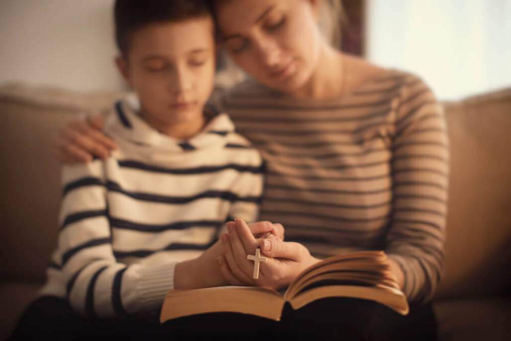 mãe e filho rezando (shutterstock) mãe e filho rezando (shutterstock)