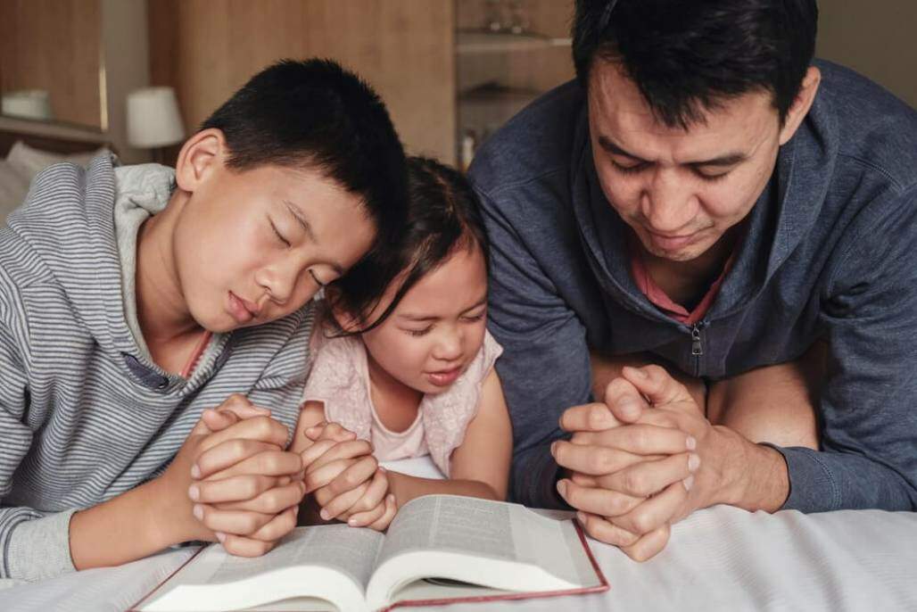 família lendo a bíblia (SewCream/Shutterstock) família lendo a bíblia (SewCream/Shutterstock)