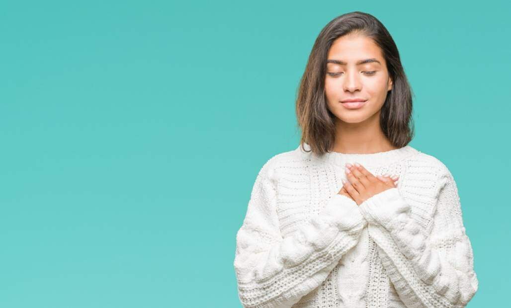 Jovem com as mãos no coração com os olhos fechados em um gesto de oração e agradecimento (Shutterstock/ Krakenimages.com) Jovem com as mãos no coração com os olhos fechados em um gesto de oração e agradecimento (Shutterstock/ Krakenimages.com)