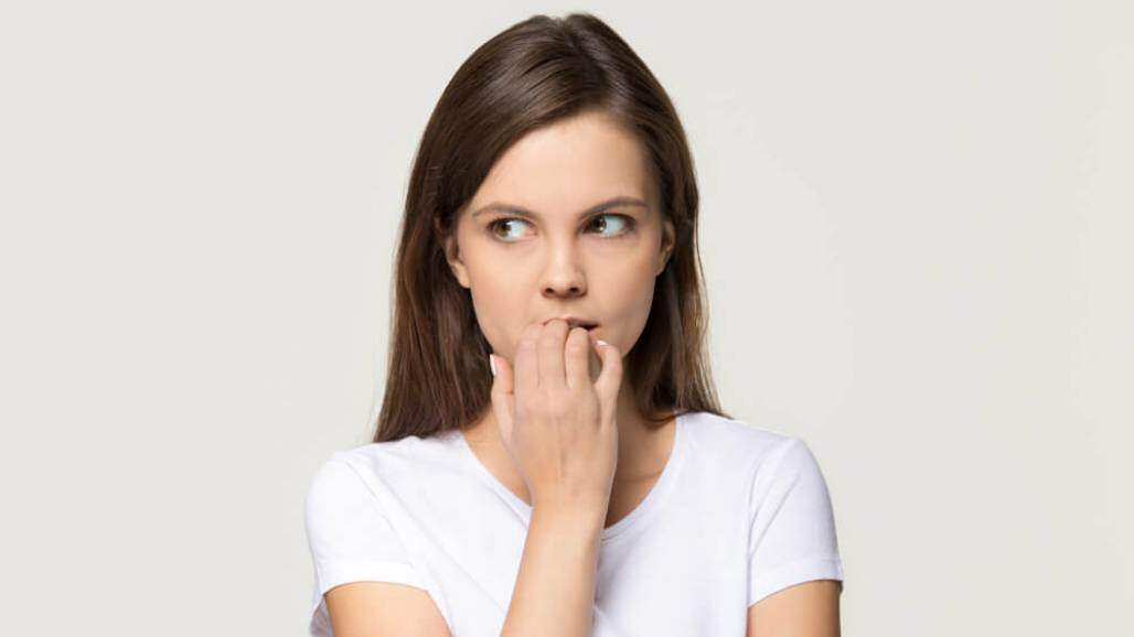 Jovem ansiosa, roendo as unhas (Shutterstock/ Fizkes) Jovem ansiosa, roendo as unhas (Shutterstock/ Fizkes)