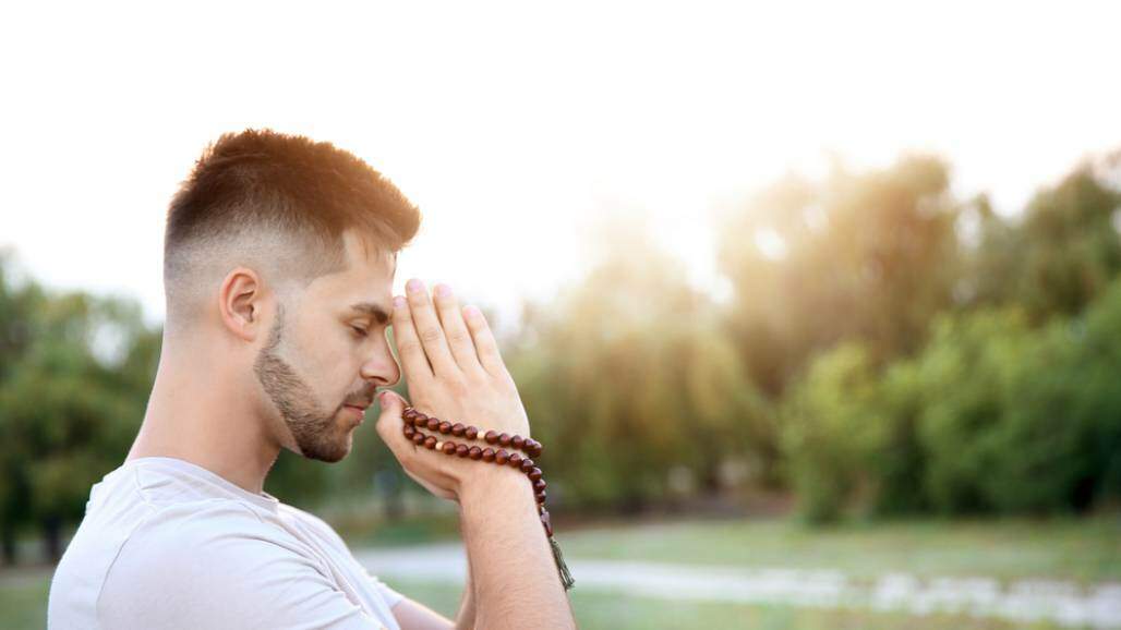 Jovem rezando o terço (Shutterstock/ Pixel-Shot) Jovem rezando o terço (Shutterstock/ Pixel-Shot)
