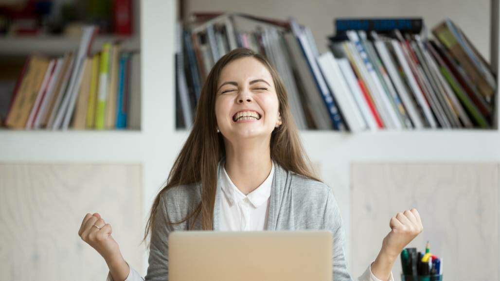 jovem comemora vitória, alegria (Shutterstock/ Fizkes) jovem comemora vitória, alegria (Shutterstock/ Fizkes)