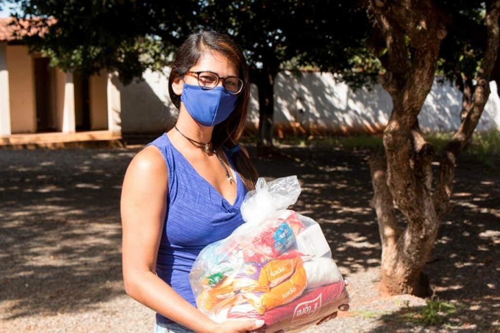 Jovem com uma cesta básica nas mãos; partilha (Shutterstock/ Marcos Casiano) Jovem com uma cesta básica nas mãos; partilha (Shutterstock/ Marcos Casiano)