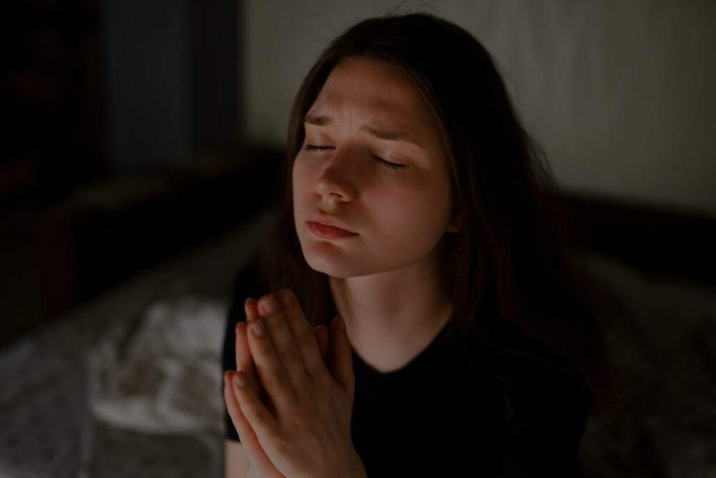 Jovem faz a sua oração a noite. (Shutterstock/ Pavlo Safonof) Jovem faz a sua oração a noite. (Shutterstock/ Pavlo Safonof)