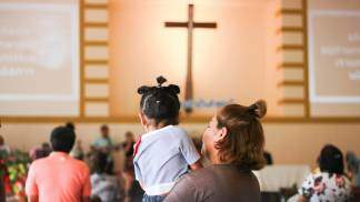 mãe com filha na igreja durante missa