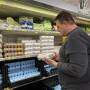 homem no supermercado conferindo ovos