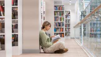 Mulher lendo um livro na biblioteca