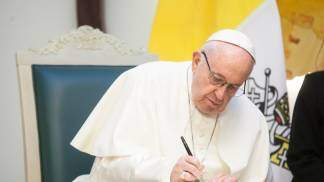 Papa Francisco assinando um documento