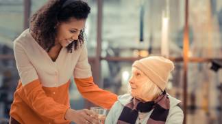 Mulher é gentil com uma idosa ao lhe oferecer um copo de água