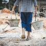 criança carregando baldes em obra