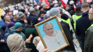Uma mão segurando um quadro do Papa João Paulo II