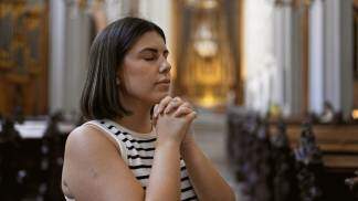 mulher rezando dentro da igreja