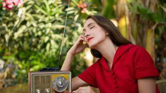 Mulher rezando com a Rádio