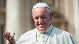 papa francisco sorrindo com a mão estendida