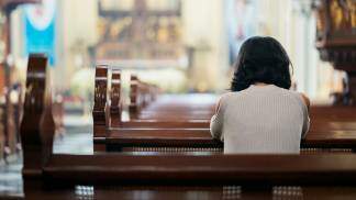 pessoa rezando na igreja