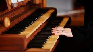 Mãos tocando piano na celebração