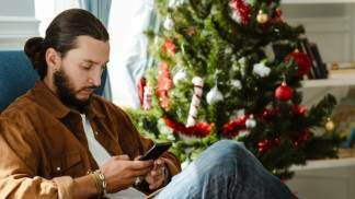 Homem mexendo no celular no natal