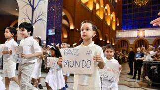 Criança com placa pedindo paz