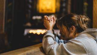 mulher rezando dentro da igreja