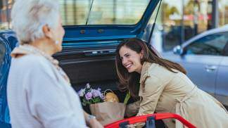 Mulher ajudando uma senhora com as compras