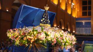 Imagem de Nossa Senhora Aparecida dentro de um baú azul com rosas na Novena Solene 2025