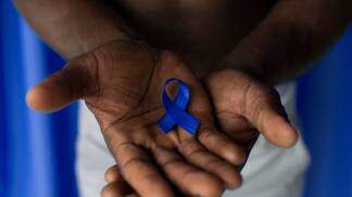 mão negra segura fita azul de novembro azul