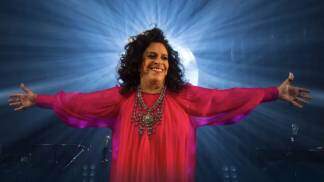 gal costa sorri e está de braços abertos