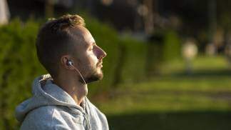 Homem com fone de ouvido pensando e escutando música