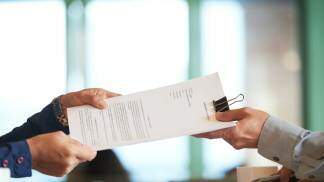 Duas pessoas trocando contrato