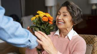 mulher sorridente recebendo flores