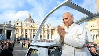 papa leao xiv no papamovel com as mãos postas sorrindo cumprimentando fieis na praça são pedro em 2025