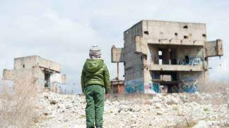 criança no meio de destroços da guerra ucrania e russia