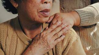 moça idosa dá a mão para moça mais jovem em seu ombro