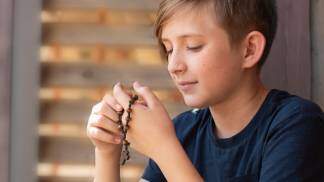 menino rezando o terço mariano 