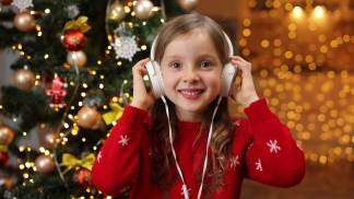 crianca ouvindo musica proximo a arvore de natal