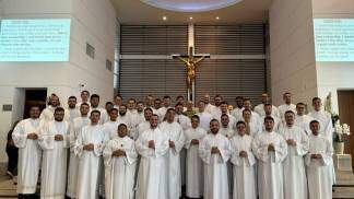 Padres brasileiros posicionados lado a lado em frente ao altar