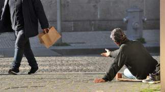 homem mendigo pedindo auxilio enquanto outro homem faz compras