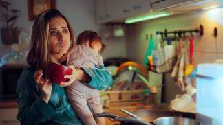 mae com crianca no colo e um copo de cafe estressante