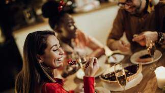 mulher-feliz-comendo-torta-alegre-enquanto-jantando-de-natal-com-amigos-em-casa_Easy-Resize.com