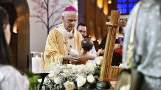 dom orlando coloca imagem do menino jesus sobre a manjedoura no altar central na missa de natal 2025