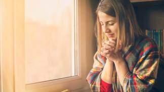 mulher rezando com bíblia