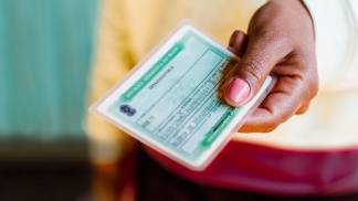 eleitora segurando o título de eleitor brasileiro