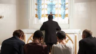 Pessoas ajoelhadas rezando