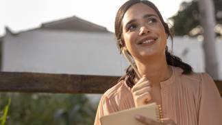 Mulher sorrindo e listando as novas metas de ano novo