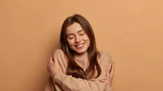 Mulher e abraçando em um gesto de amor próprio