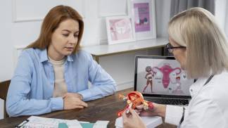 Médica explicando para a paciente sobre síndrome do ovário policistico