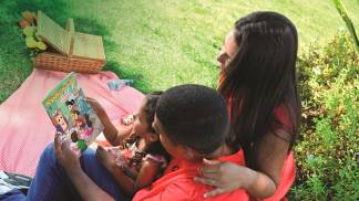 Família com livro dos Devotos Mirins