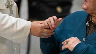 papa leão xiv segura nas mãos de uma fiel em uma audiencia geral em 2026