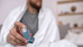 Homem adulto com sua bombinha de ar para problema respiratório