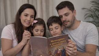 família rezando com livro 